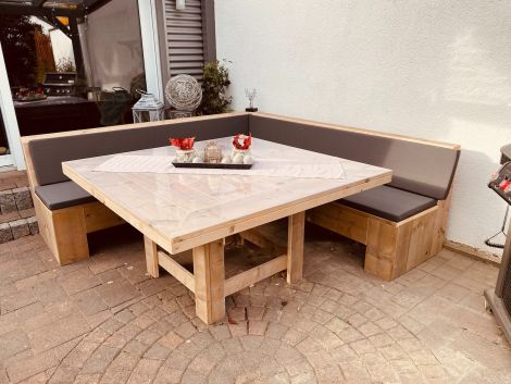 Bauholz Gartentisch Landsberg 145 x 145 cm mit Transparent Öl, dazu Eckbank Altdorf halb geschlossen 230 x 230 cm mit Kissen Cartenza 167 Graphite. Bitte beachten: Standard kommt der Tisch mit gerader Tischplatte.