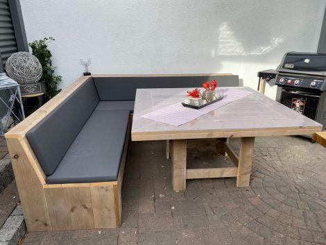 Bauholz Gartentisch Landsberg 145 x 145 cm mit Transparent Öl, dazu Eckbank Altdorf halb geschlossen 230 x 230 cm mit Kissen Cartenza 167 Graphite. Bitte beachten: Standard kommt der Tisch mit gerader Tischplatte.